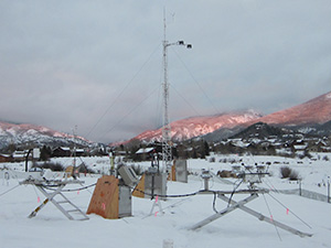 The sun breaks through the clouds to shine on the mountains behind AMF2 instruments located on the valley floor at Steamboat Springs.