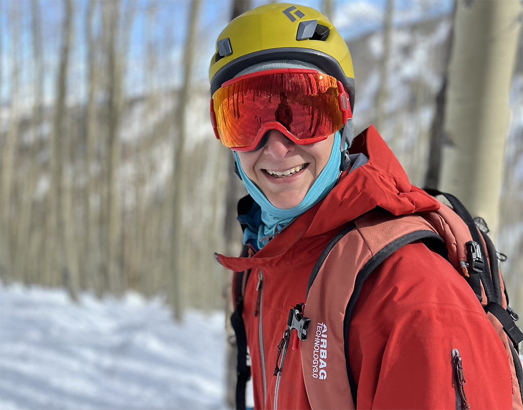 Wearing ski goggles, William “Will” Rudisill pauses on a ski trail to smile at the camera.