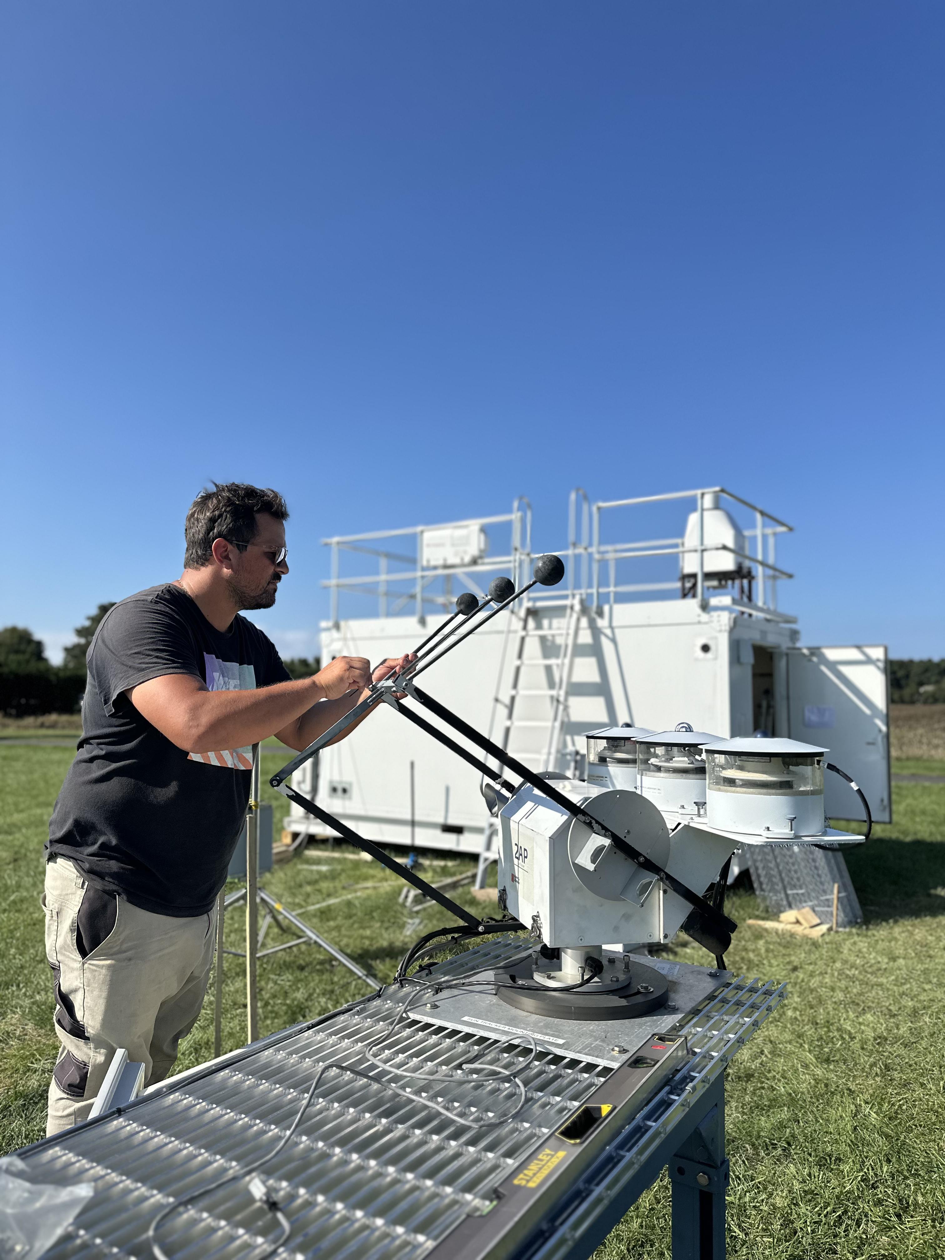 A person leans over to look at the adjustment they are making to a set of radiometers.