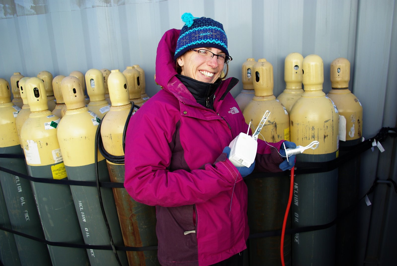 Jen Delamere wears a fuchsia jacket and blue striped beanie.