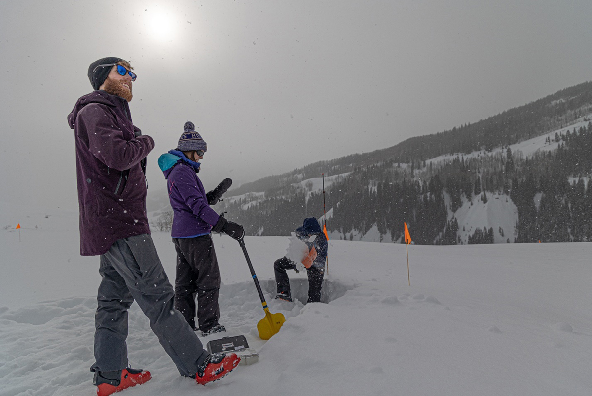 Danny Hogan looks up while Jessica Lundquist waits for Eli Schwat to climb out of the snow pit.